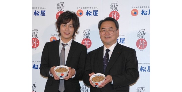 松屋フーズ・代表取締役社長の緑川源治さんと牛めしを持って並ぶ溝端さん