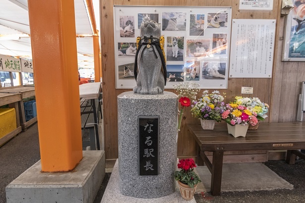 生簀の脇にはねこ駅長の銅像が立っている