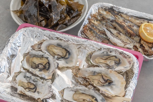 「焼き岩ガキ」(1個100円)、「真イワシの丸干し」(1串380円)、奥にあるのが「鳴門ワカメ」