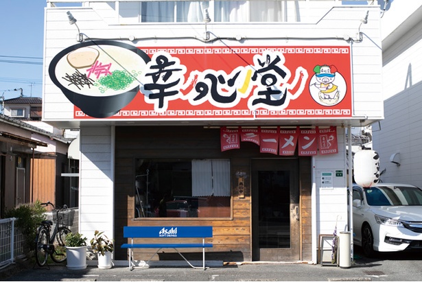 店主の父が描いた豚のイラストが目を引く。目の前に駐車場がある / 幸心堂
