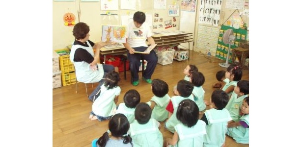 子どもたちに絵本を読み聞かせる