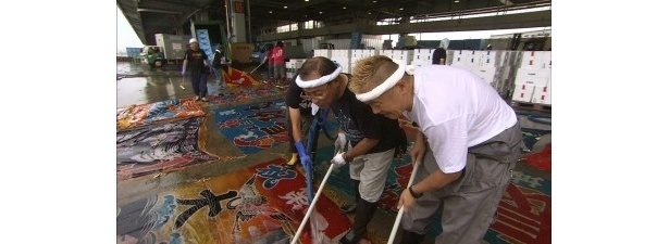 漁師と一緒に大漁旗を洗う