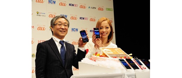 新サービス「auスマートバリュー」のスタートを祝って､スマートフォンと固定電話をあしらったケーキも登場。左はKDDI株式会社の甘田純一コンシューマ関西支社長