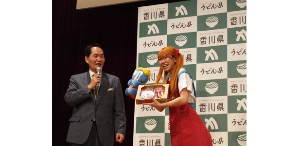 うどん県（香川県）の浜田恵造知事（写真左）からお笑い女性タレントの桜 稲垣早希（右）にプレゼントが渡された