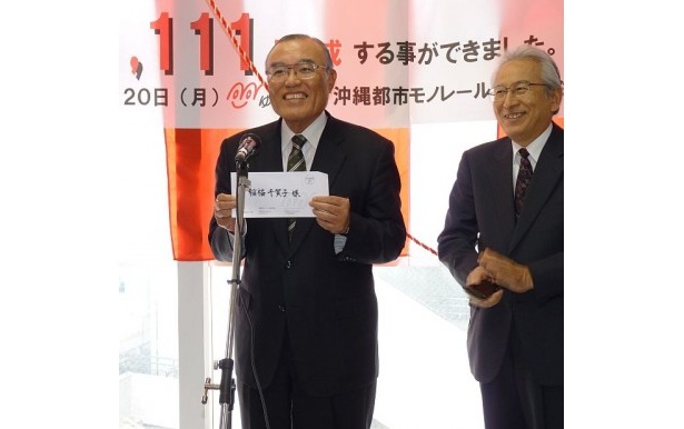 笑顔で当選者を発表する仲吉良次社長