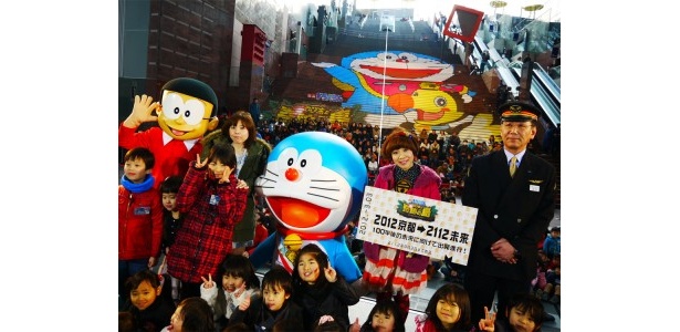 京都駅ビルのステップアートをバックに、ドラえもん役の水田わさびさん、のび太役の大原めぐみさん、JR京都駅の津田昭司駅長！