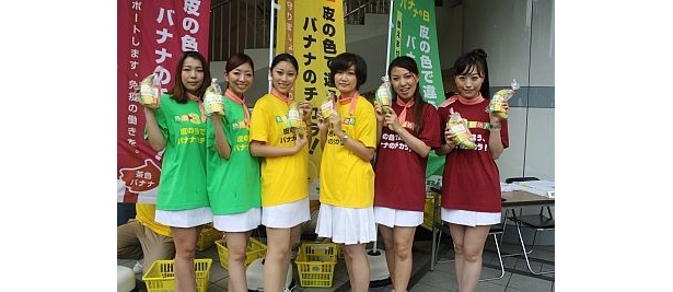 【写真を見る】皮の色をイメージした3色のTシャツでバナナを配布する女性たち