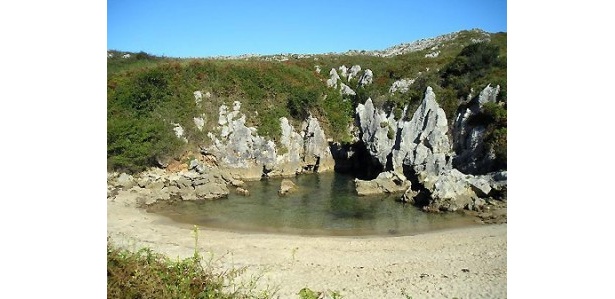 スペインの「Playa de Gulpiyuri」。海岸から100m程離れた草原の真っ只中、海から続く細かな洞窟が海水を引き込んでできた