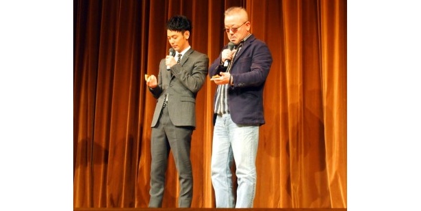 黄金のプレートを渡され、持って帰ろうとする二人