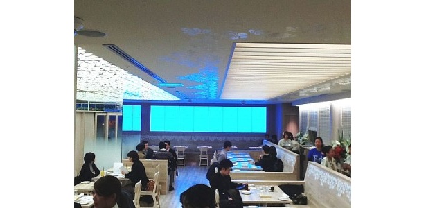 新店舗では70席を用意。8台並んだ55インチディスプレイは、ハワイの風景を映し出す
