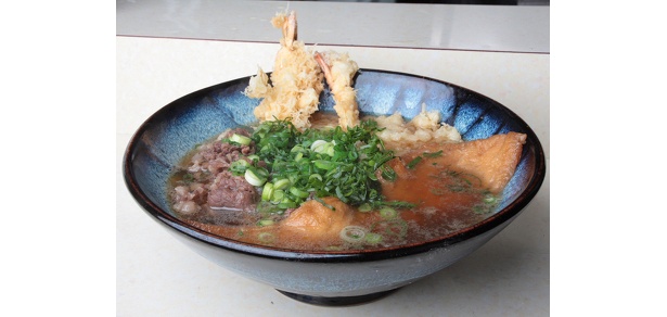 「饂飩倉」の「肉天あげ」(2100円)。揚げたてサクサクのエビ天がドドーンと2尾、そしてダシが染みこんだでっかい“お揚げさん”にたっぷりの牛肉と豪華な具材が、直径28cmのビッグな器にのって登場!!