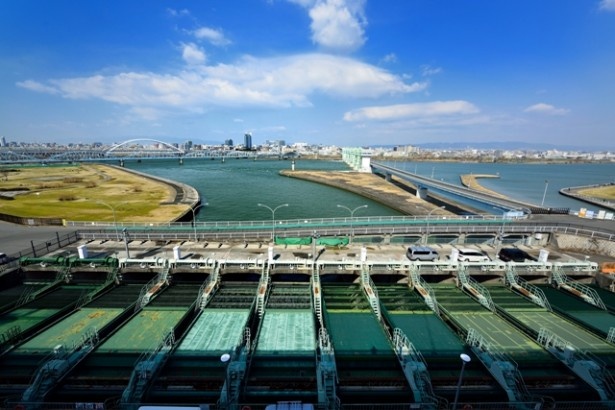 毛馬排水機場の北側、淀川を望む。手前の緑の装置は、大川から流れ込む水のごみを漉しとる役割をもつ
