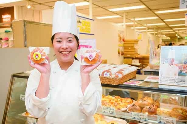 販売スタッフの川島　幸恵さん。手にもつ「えび～にゃのおやつ」（210円）は、海老名市内・泉橋酒造の米粉を使用したマドレーヌ/ラ・パティスリー