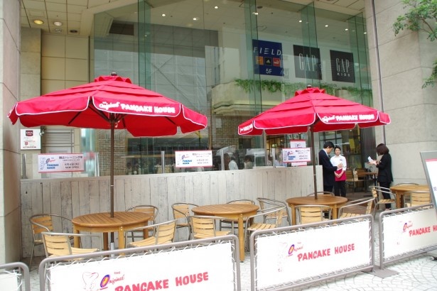 パンケーキハウスの赤いパラソルが目印の店舗入り口にあるテラス席