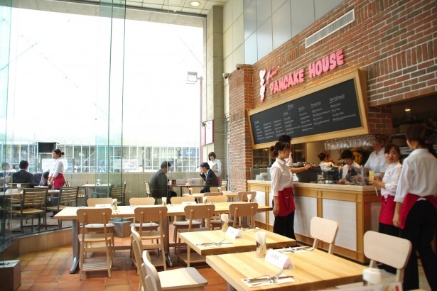大きな窓ガラスと吹き抜けが開放的な明るい店内