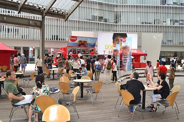 受け取ったその場でコカ・コーラを楽しむ人が大勢いた