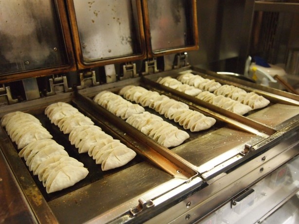 餃々オリジナルの鉄板で焼かれる餃子