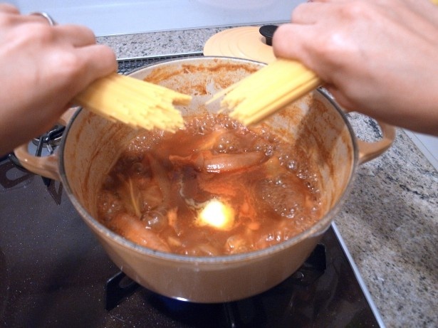 残ったスープに水を入れ、半分に折ったパスタを投入