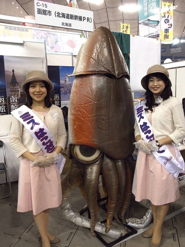 函館ブースで恐ろしい巨大イカと一緒に可愛いミスはこだての2人も