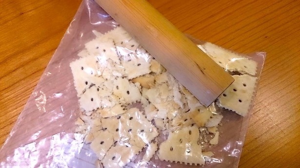 クラッカーをビニール袋に入れて粉々に砕き、ここにバターを加えよう