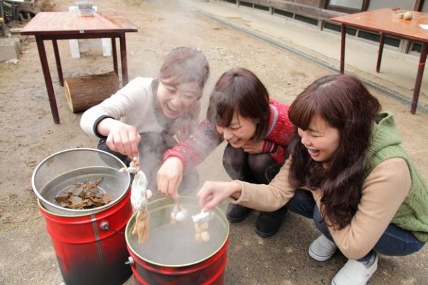 ビワの葉などを煮出した天然の染色液に漬けて、しばらく置く。