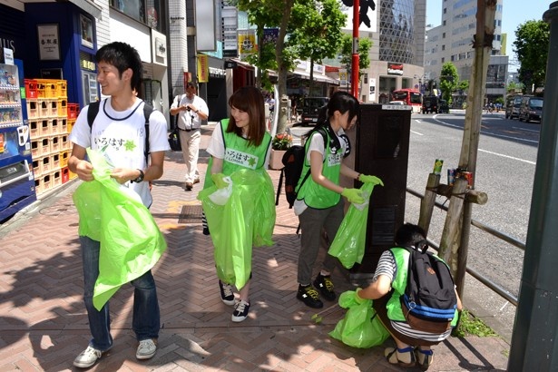大通り沿いの歩道でゴミを拾う参加者たち