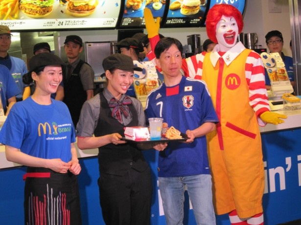 【写真を見る】6月12日(木)実施の「ジャパンバーガー ビーフメンチ」先行販売セレモニーで、青い服などを着て来店した先着200名にスペシャルセットがお試し価格の500円で販売された