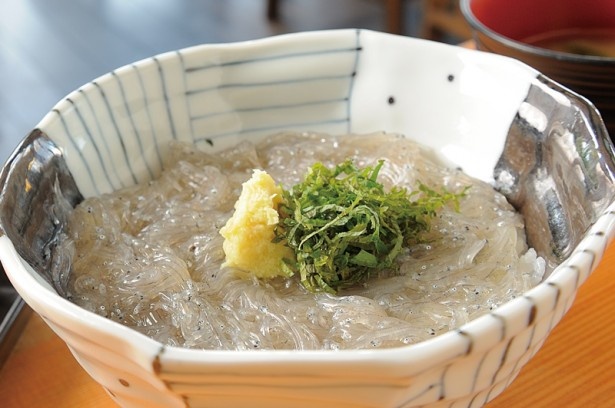 【写真を見る】「しらすや 腰越漁港前店」の生しらす丼(864円、味噌汁・新香付き)。酢飯の上に約150gの生シラスがのり、大葉などを添えたシンプルな一杯