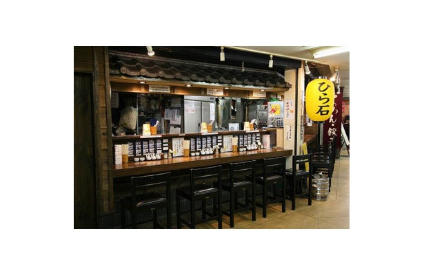 【らあめん ひら石】食材店や飲食店が軒を連ねる市場の一画。通路との隔たりのない、カウンターのみの雰囲気は、その気軽さも魅力の一つだ