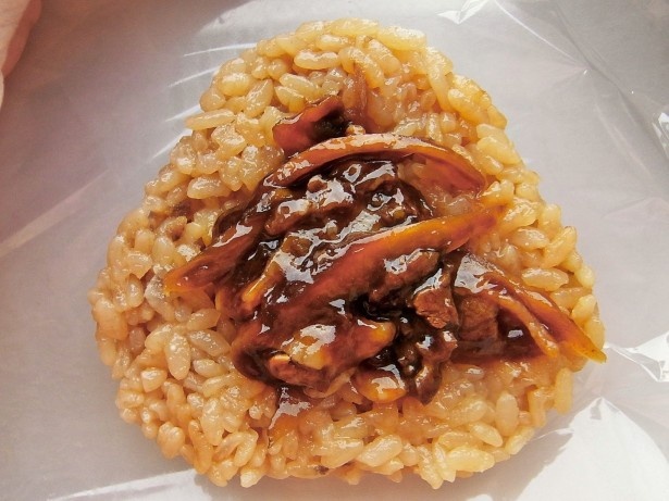 特製タレで味付けした牛肉とゴボウが入った「柿安本店監修 牛むすび」(198円)は、牛肉そぼろ和えご飯で握って海苔を巻き、食べごたえ満点！(写真は断面)