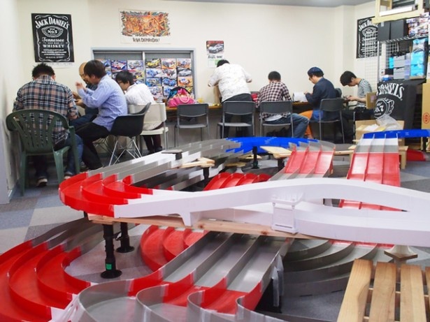 店内スペースの大半を占めるサーキット。周辺の作業台では男性客が愛車のカスタムに没頭していた