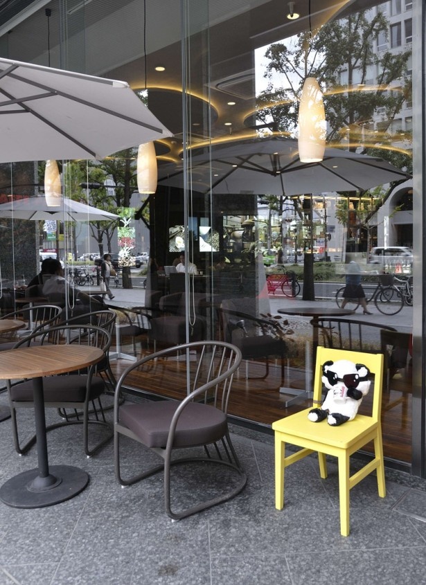 御堂筋沿道のカフェで黄色い椅子に座るグラサンパンダ。スタンプラリーのスポットだ