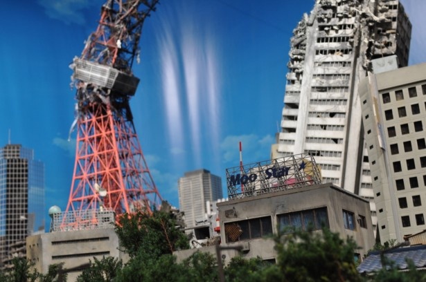 【写真を見る】日常的な光景を再現し、高層ビルやシンボルタワーの崩壊を描いた「特撮スタジオミニチュアステージ」