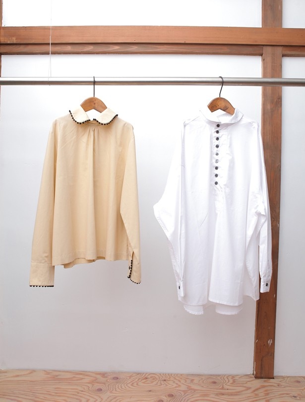 左から、そで口と襟に球状の飾りをあしらった後空きブラウス（￥16,524/9号）、小さめの襟でキュートさを演出するコットンプルオーバー（￥14,688/フリーサイズ）【灰汁/aku】