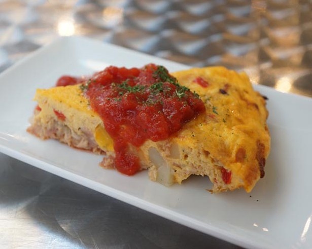「BISTRO 川崎 CITTA スタンド」のスペインオムレツ￥400。ポテトやベーコンなどの具材がたっぷりと入ったオムレツ、上にのったトマトソースもおいしそう