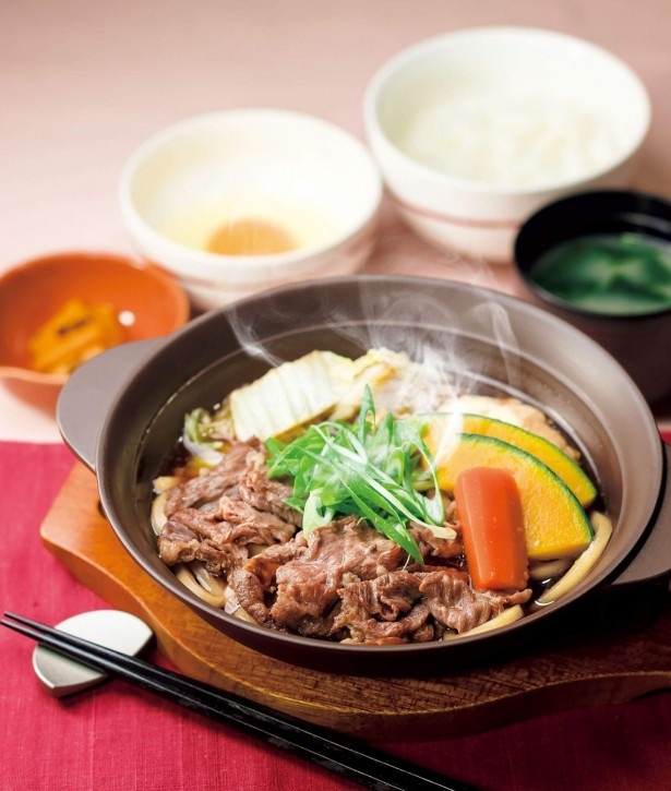 【写真を見る】牛肉と白菜、九条ネギ、寄せ豆腐、うどんを甘辛いタレで煮た「京都産九条ねぎと寄せ豆腐の牛すき鍋」(税抜699円)。卵をつけて食べる
