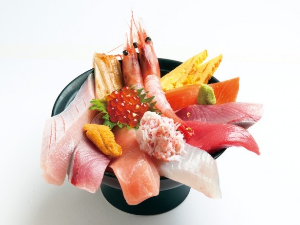 【写真を見る】丼から溢れる大ぶりのネタがたまらない！甘エビ、ブリ、中トロ、カニなど、厚切りのネタを約12種類をトッピングした、じもの亭の「海鮮丼・華」(2250円)