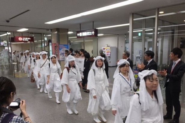 荷物を受けてロビーに流れ込む白装束女子の行列に一般の人も注目