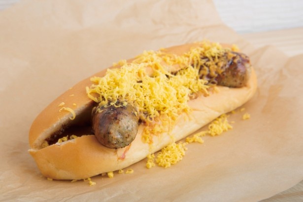 チェダーチーズをトッピングした、SUPER HOTDOGの「ホットドッグJr.」(350円)。柔らかくほのかに甘味のあるドッグは、地元のパン店によるオリジナル