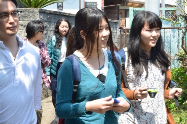 スマートフォンやカメラを手に真鶴町を散策する多摩美術大学の学生
