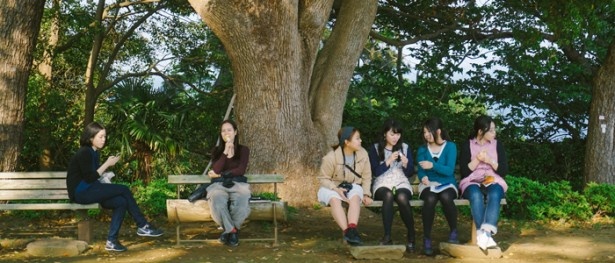 巨木の前で休憩する多摩美術大学の学生たち