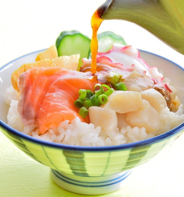 【写真を見る】天然ホタテ、イクラ、タコ、サーモンなどが乗った「海鮮丼」。シェフが目の前で仕上げてくれる