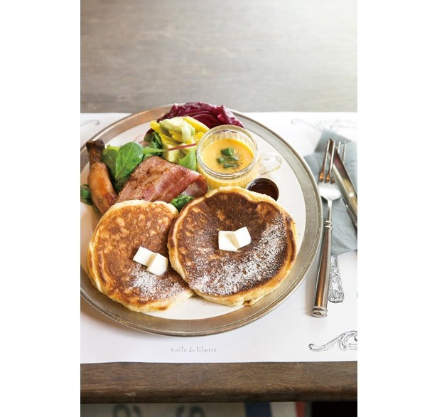 【写真を見る】「パンケーキプレート」(1360円)のパンケーキは、北海道産小麦粉で作るふわふわ食感が魅力。生地の下にはリンゴソテーが隠れている