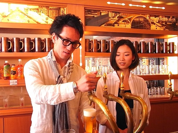 札幌開拓使麦酒賣捌所にて。「本当に難しい(笑)」と、泡とのバランスを考えながら、真剣な表情でビールを注ぐ岩崎さん(写真・左)と、馬場さん(同・右)