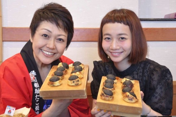  「前髪切りすぎたたこ焼」を手に「道頓堀たこ祭」をアピールする三戸なつめと日本コナモン協会の熊谷真菜会長