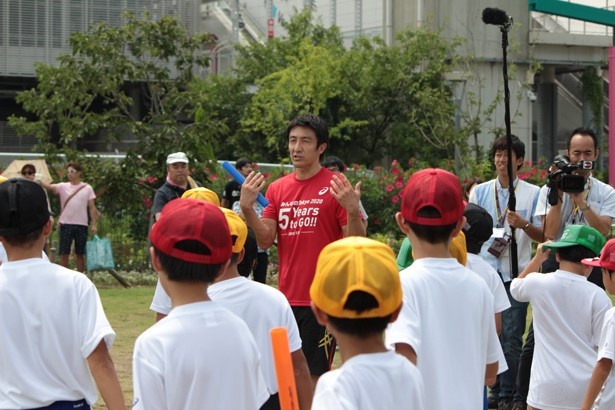 参加した小学生にわかりやすくバトンパスのコツを伝える朝原宣治さん