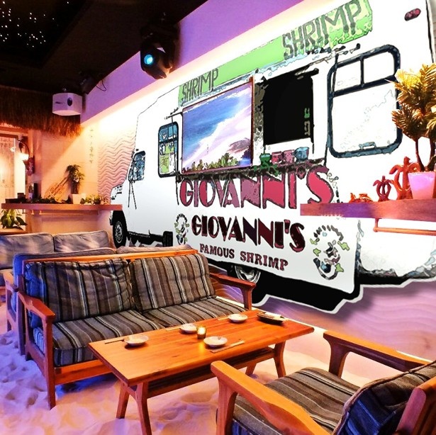 【写真を見る】白い砂浜をイメージした店内。壁にはジョバンニーズの移動車の絵も