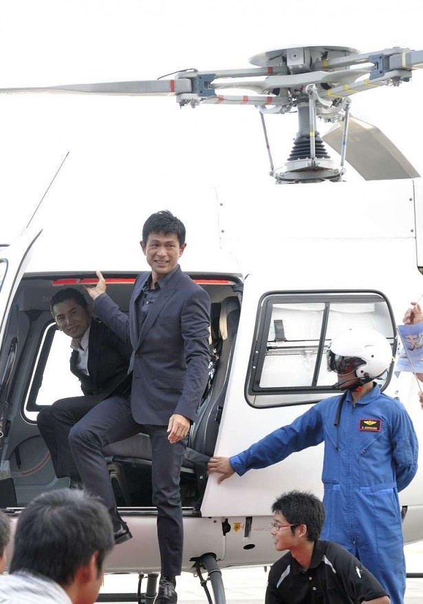 ファンに迎えられ、ヘリコプターから降り立つ江口洋介と本木雅弘（左）