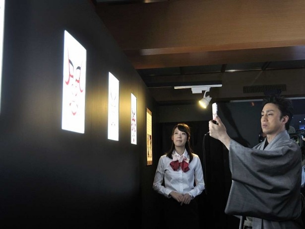 パナソニックの「光ID」の展示を体験する染五郎。スマホを隈取の映像にかざすと、信号を読み取り、その隈取の名前や概要がスマホのディスプレイに表示される