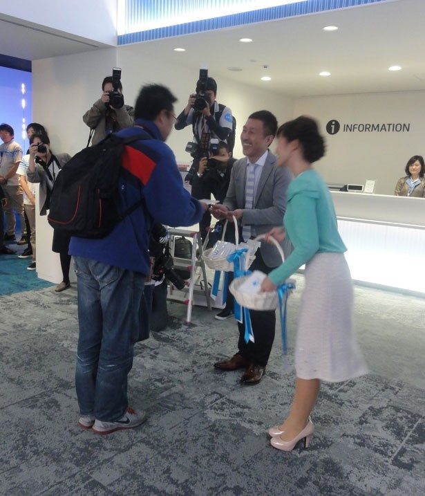 「NIFREL」の1番客に来館プレゼントを渡す館長の小畑洋さん